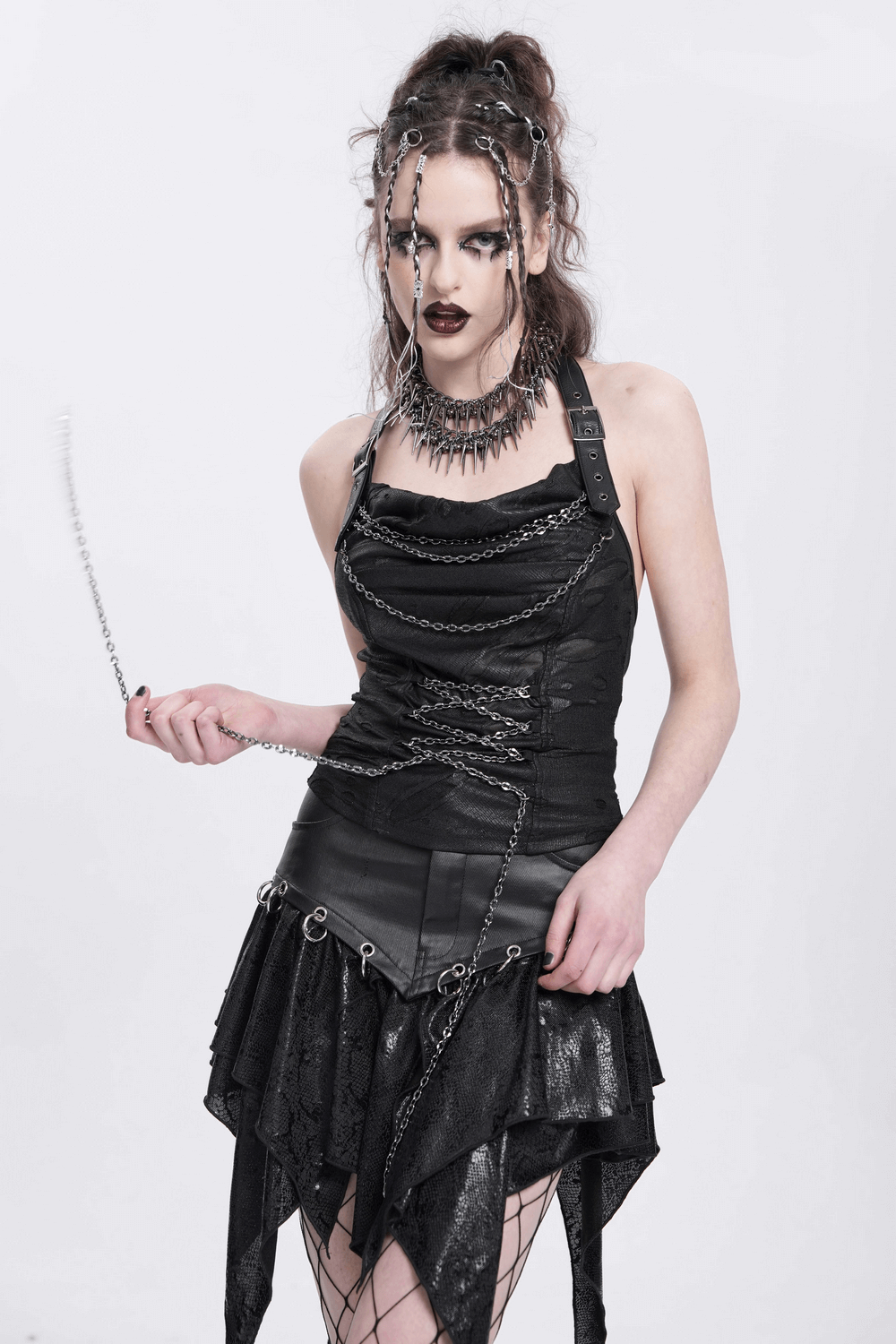 Gothic black halter top with chains, lace-up detail, and adjustable straps, styled with punk accessories in an edgy look.