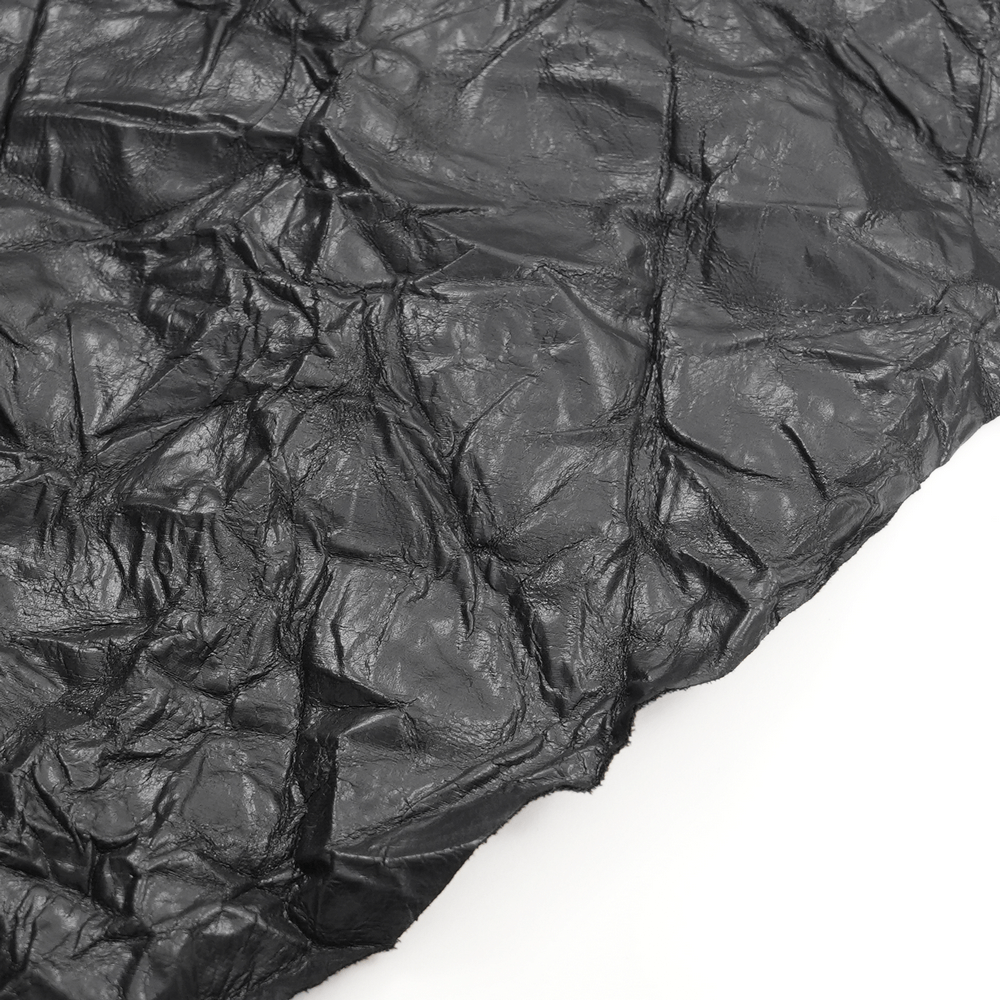 Close-up of black crinkled leather texture showcasing the unique design of a Gothic kilt fabric.