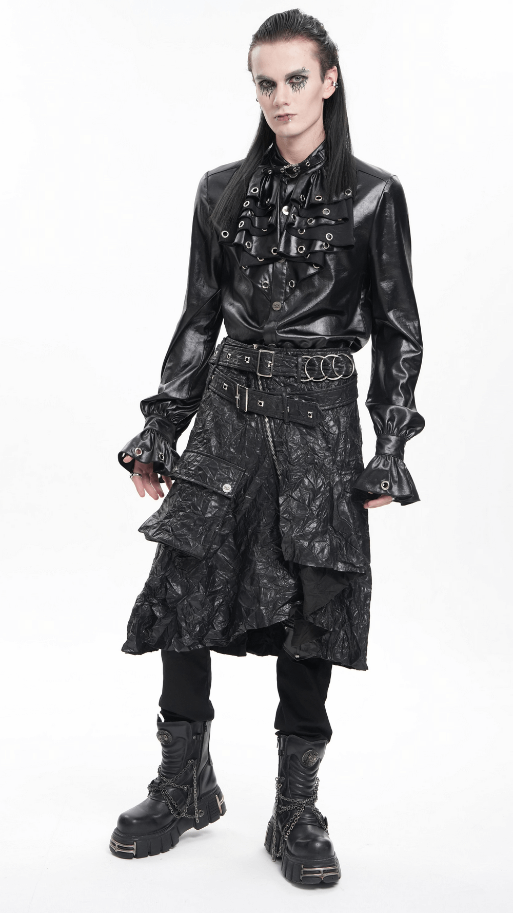 Model wearing a gothic black crinkled leather kilt with buckles, paired with a stylish black ruffled shirt and edgy boots.