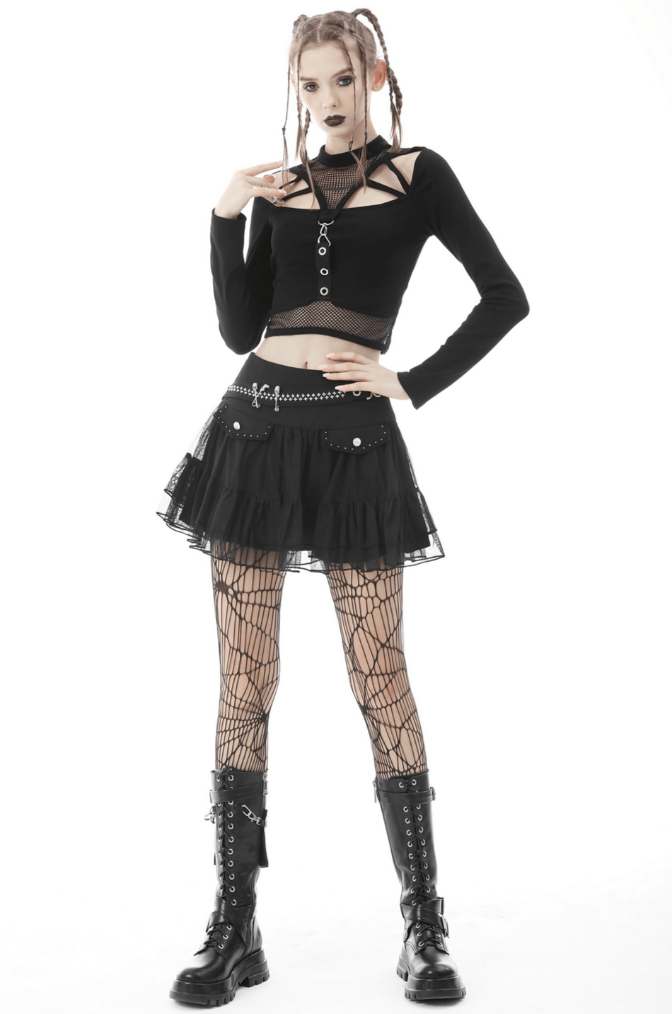 Edgy gothic woman in black crop top with fishnet sleeves, playful skirt, and chunky boots, showcasing rebellious style.