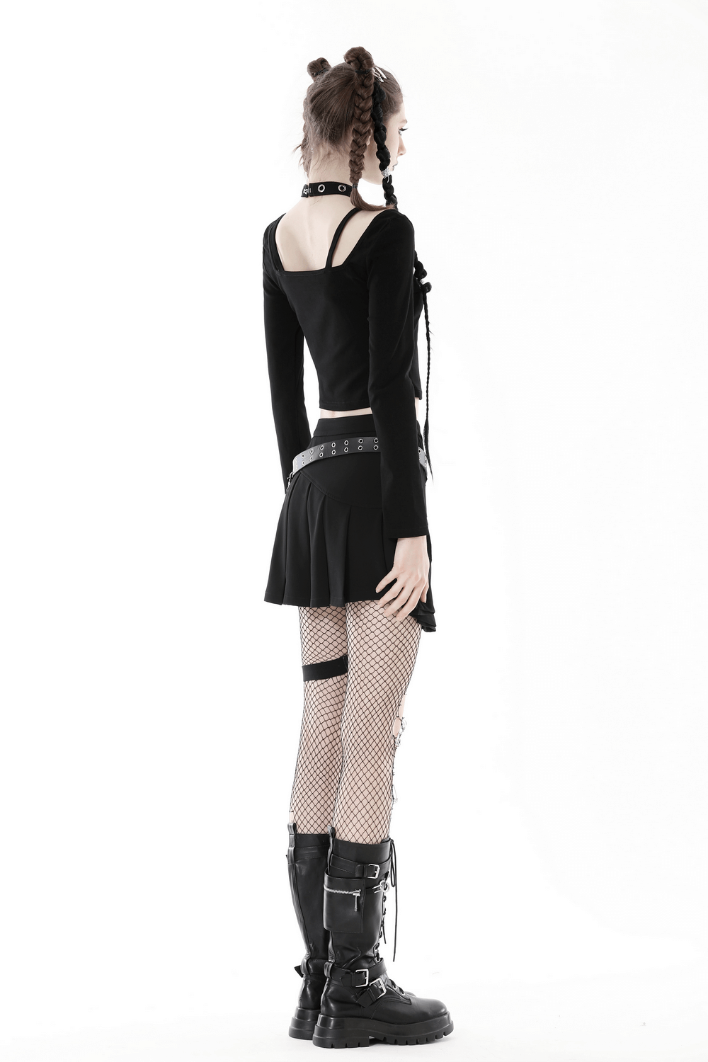 Edgy gothic crop top with metal accents and harness detail, paired with a skirt and fishnet tights, showcasing dark fashion.
