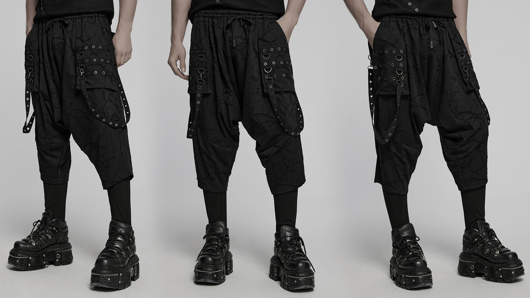 Gothic black drop crotch pants with eyelet straps and D-ring accents, showcasing a punk-inspired style.