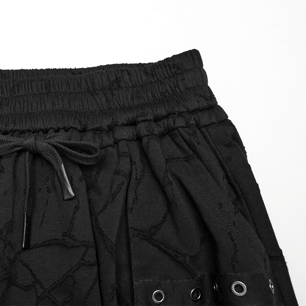 Close-up of gothic black drop crotch pants with elastic waistband and eyelet details, showcasing punk style.