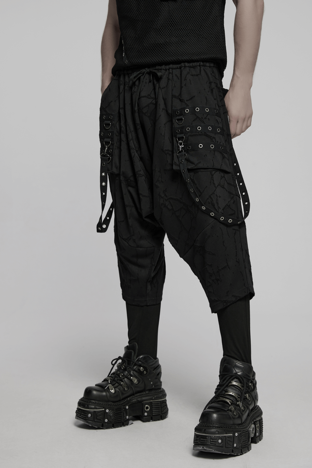 Gothic black drop crotch pants with eyelet straps and bold 3D pockets for a punk-inspired look.