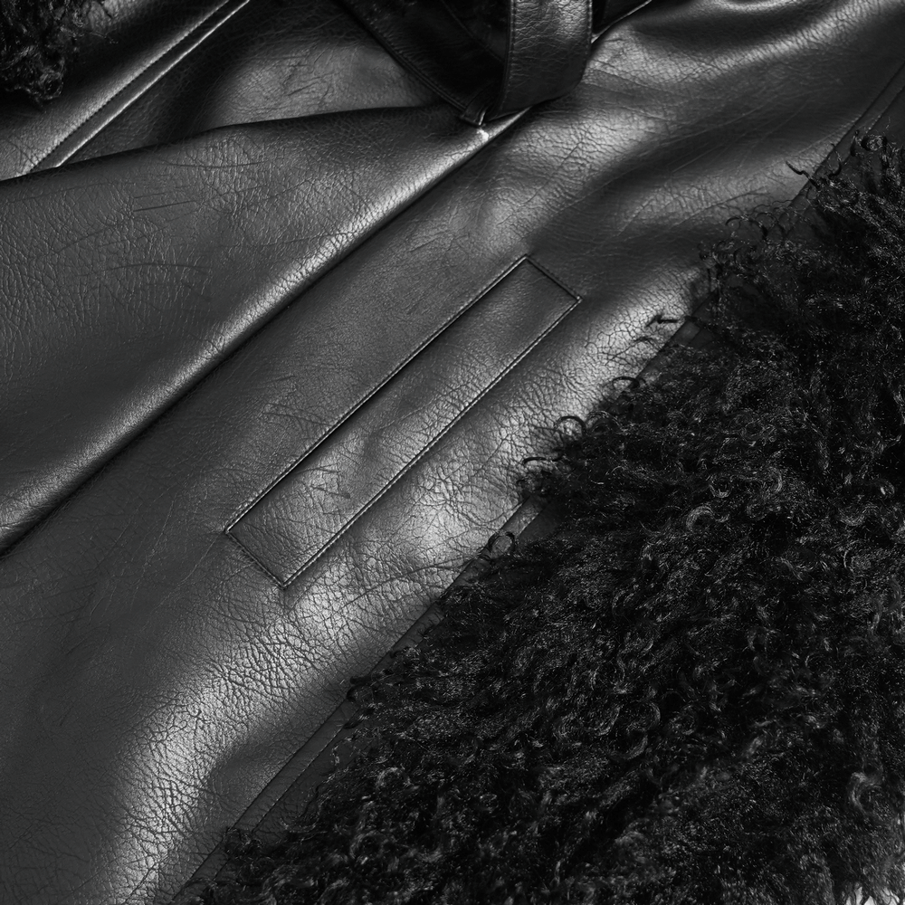 Close-up of gothic black faux leather coat with plush faux fur trim, showcasing texture and detail.