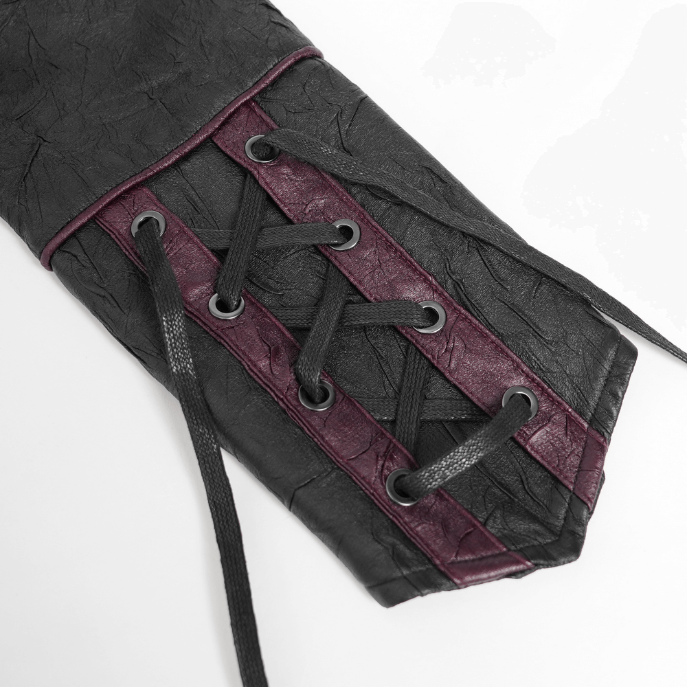Close-up of gothic black faux leather jacket sleeve with red lace-up detail and eyelets, perfect for punk fashion.