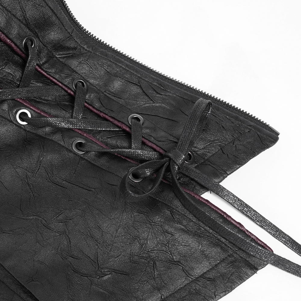 Close-up of lacing detail on gothic black faux leather jacket with red accents, highlighting punk style.