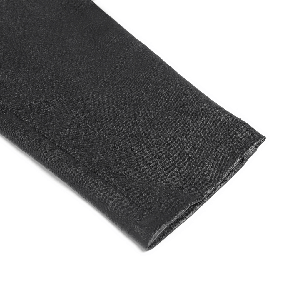 Close-up of the hem of gothic black faux leather pants with sleek finish and stitching details.