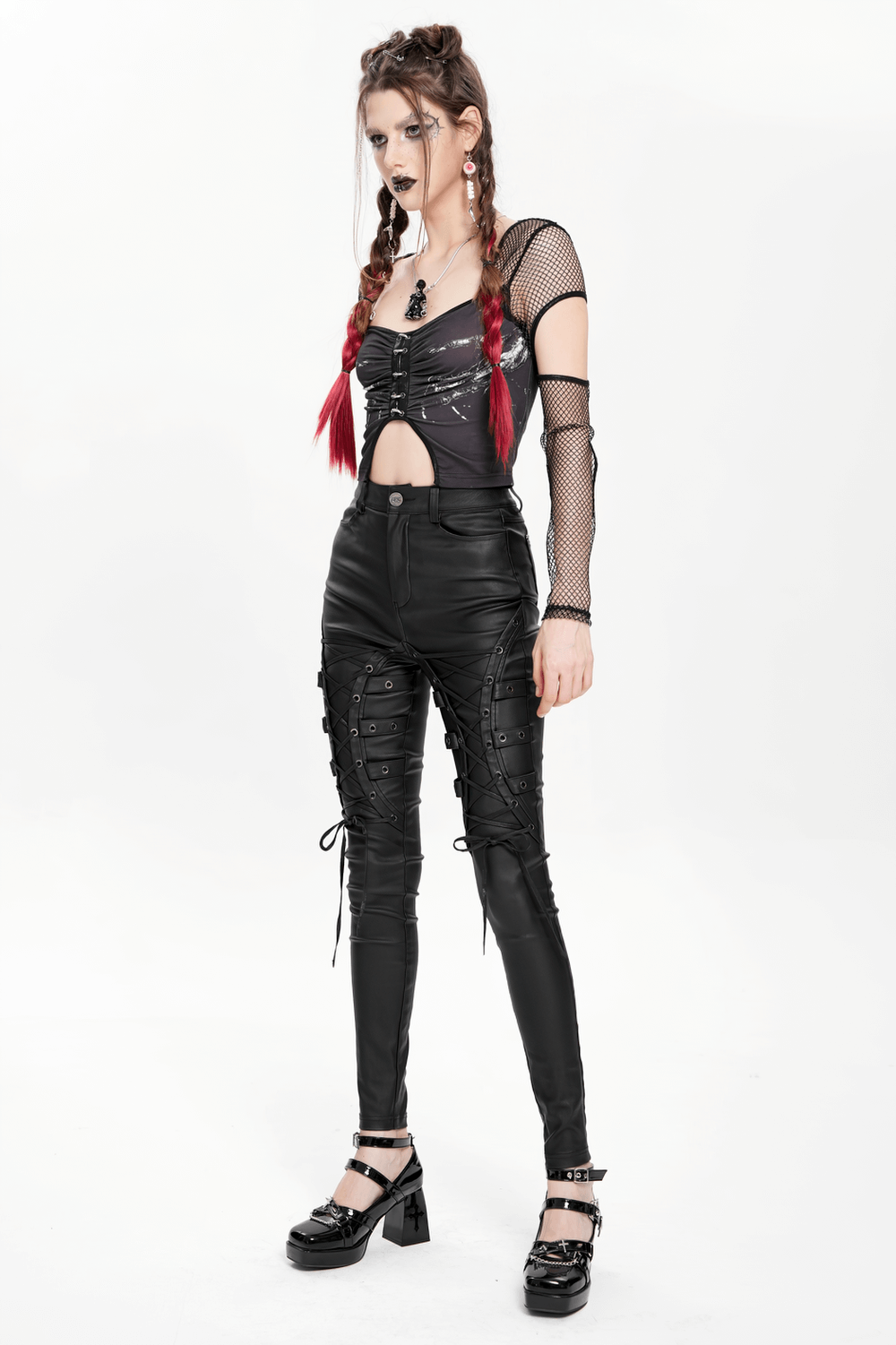 Gothic black faux leather pants with lace-up straps, paired with a stylish mesh top and bold accessories.
