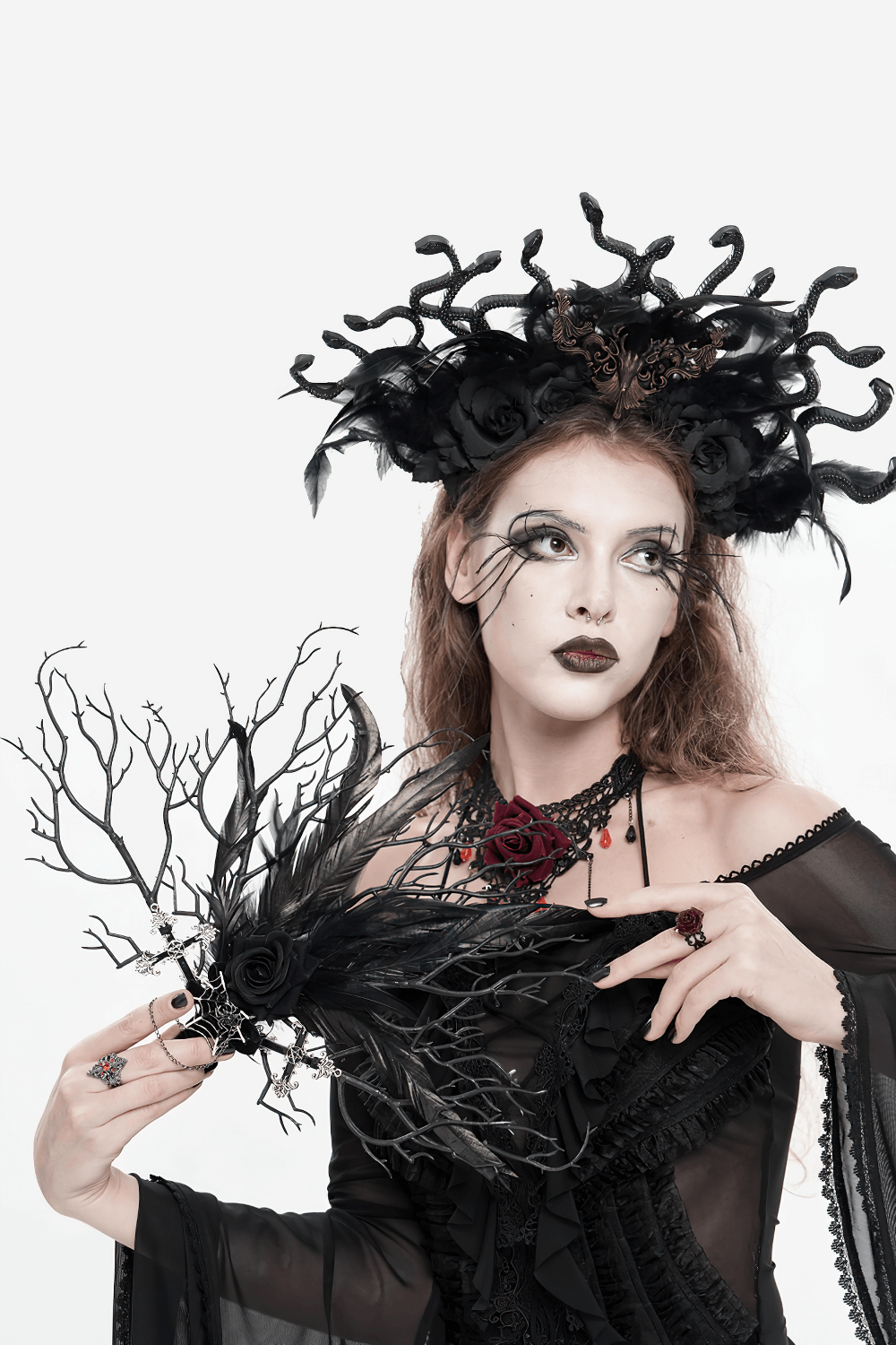 Gothic Black Feather and Twig Hand Fan with Cross Charms showcased by a model in dark attire and striking headpiece.