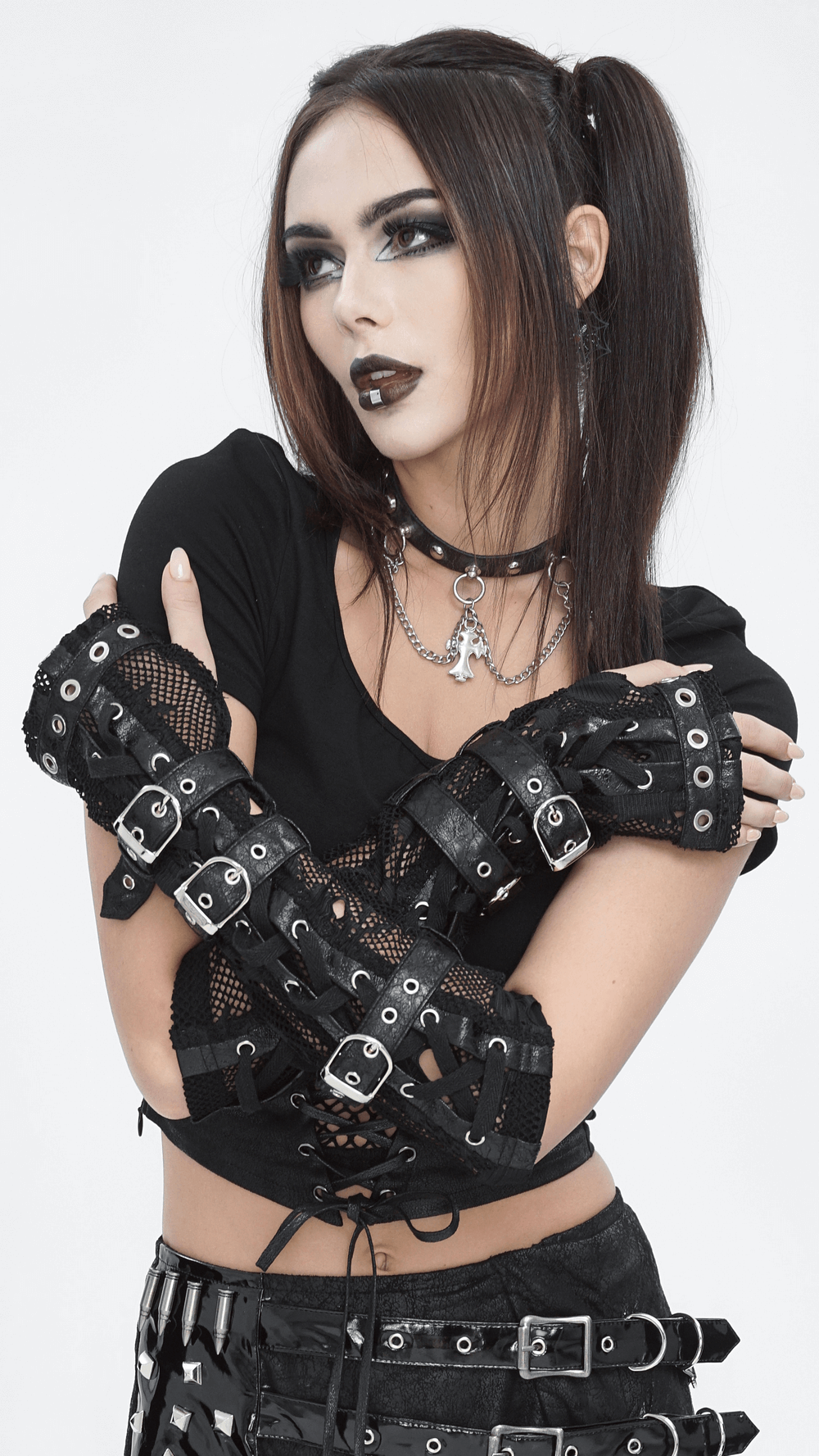 Gothic black fishnet fingerless gloves with buckles modeled by alternative fashionista, showcasing punk rock style.