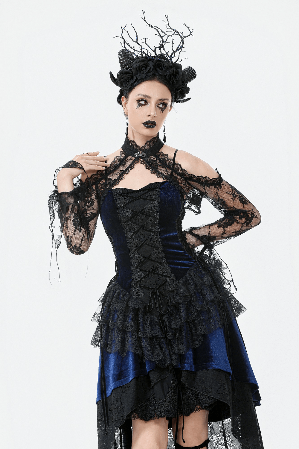 Gothic model wearing a black floral lace shrug with long flared sleeves and a dramatic corset dress.