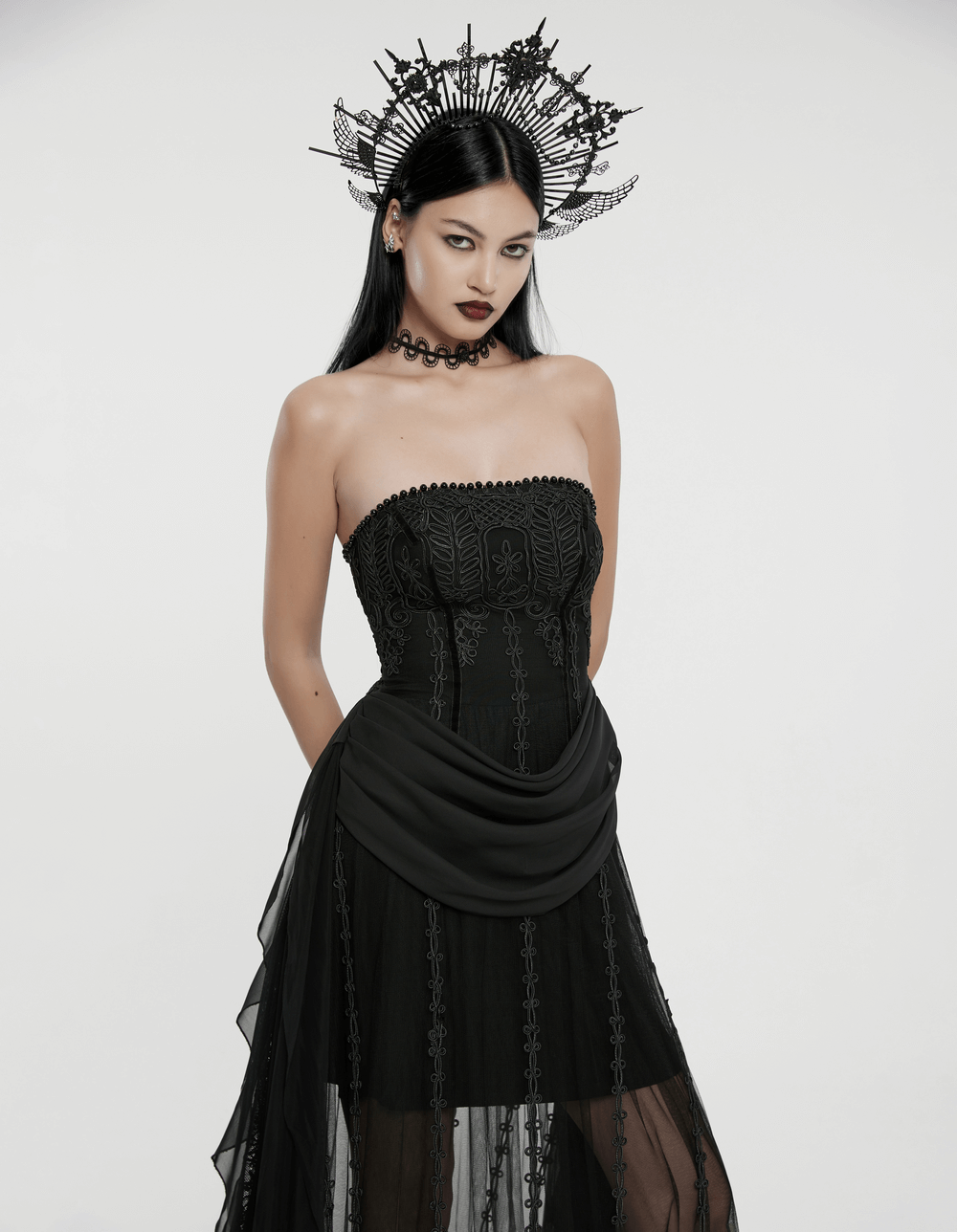 Elegant gothic black strapless dress with intricate embroidery and chiffon layers, complete with a dramatic headpiece.