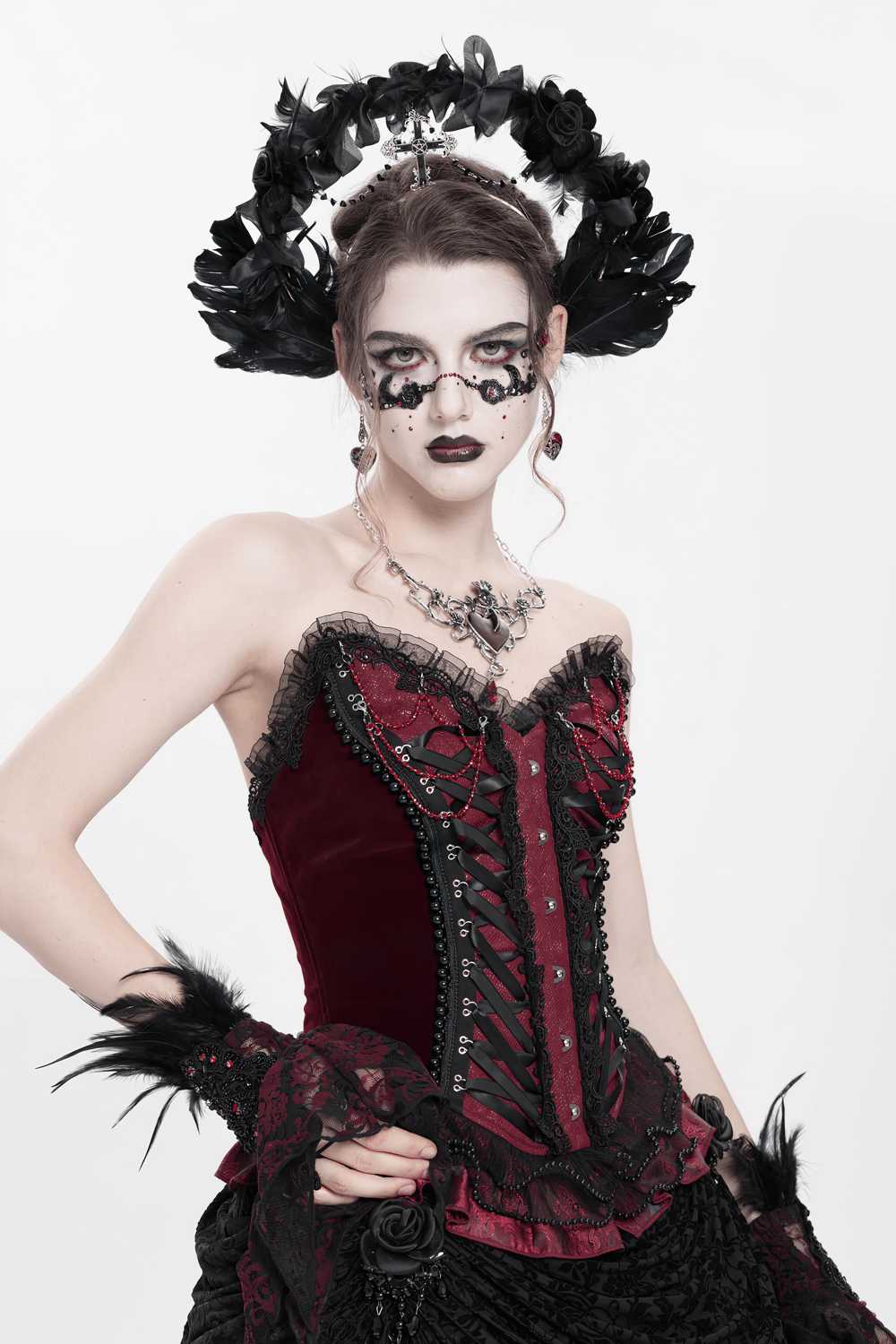 Gothic black halo crown with feathers, cross decor, and baroque style worn by a model in dark red attire.