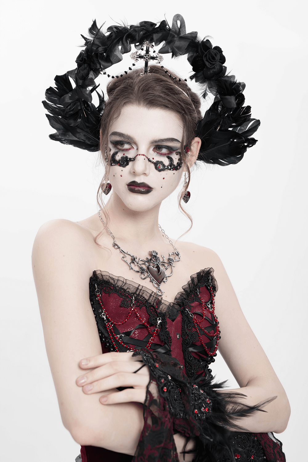 Model showcasing a gothic black halo crown with feathers, cross, and intricate rose details for dark fantasy fashion.