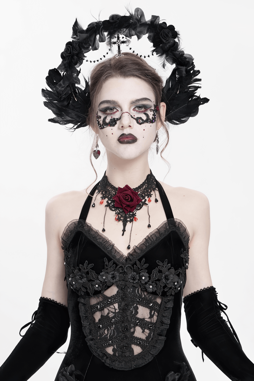 Gothic black halo crown with feathers and cross, styled with a velvet outfit and dramatic makeup.