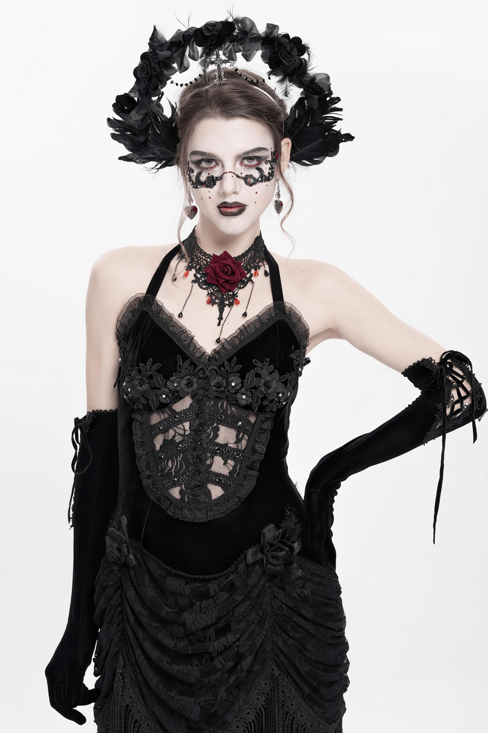 Gothic black halo crown with feathers, cross, and roses, worn by a model in elegant dark attire.