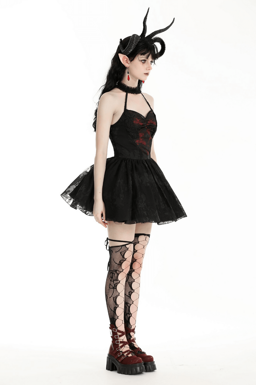 Dark gothic halter dress with lace and ruffle details, paired with stylish fishnet stockings and striking accessories.