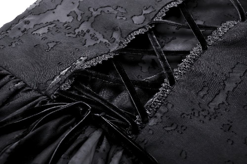 Close-up of lace and ruffle details on a gothic black halter dress, showcasing its vintage charm.