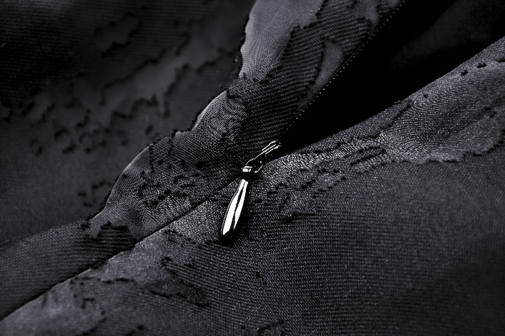 Close-up of black fabric with intricate lace details and a shiny zipper accent, perfect for gothic fashion.