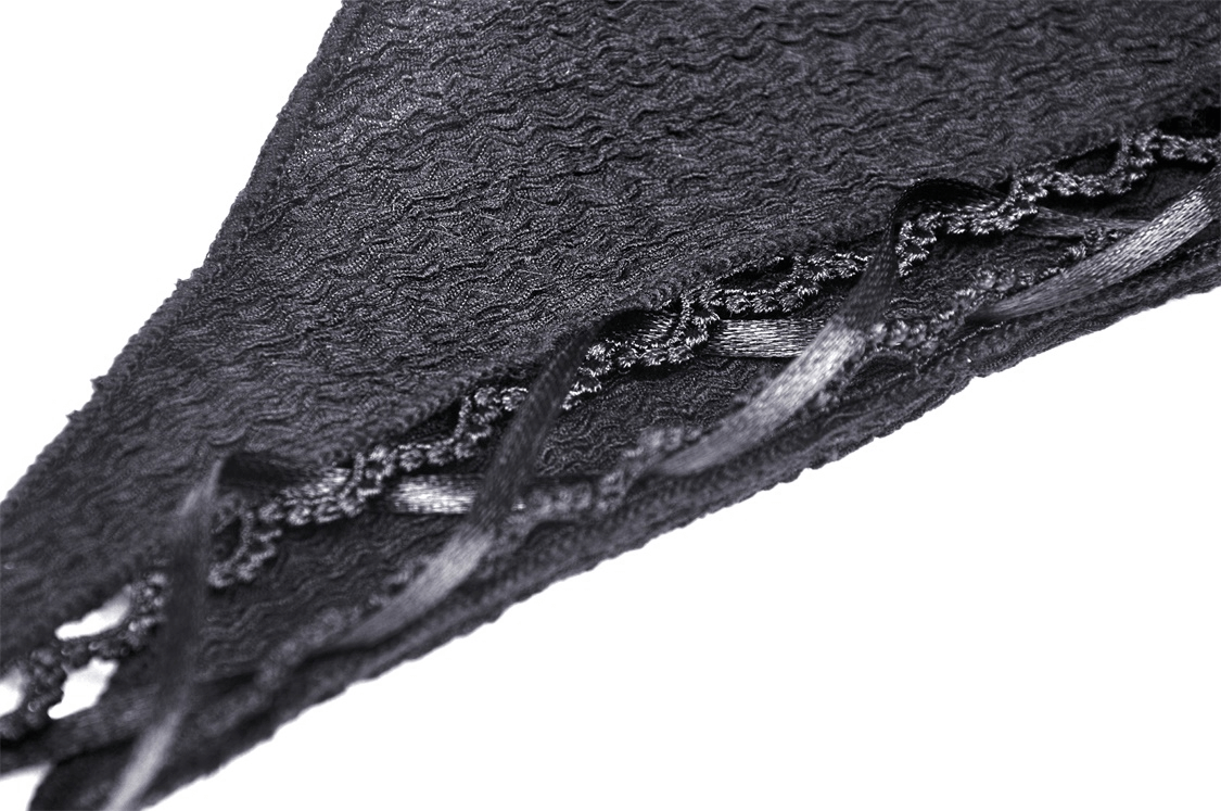 Close-up of intricate lace detailing on a black hooded crop top, showcasing edgy gothic fashion.