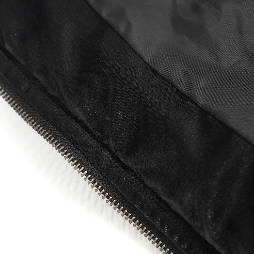 Close-up of the inner lining of a gothic black hooded jacket with a soft faux fur finish and sleek zipper detail.