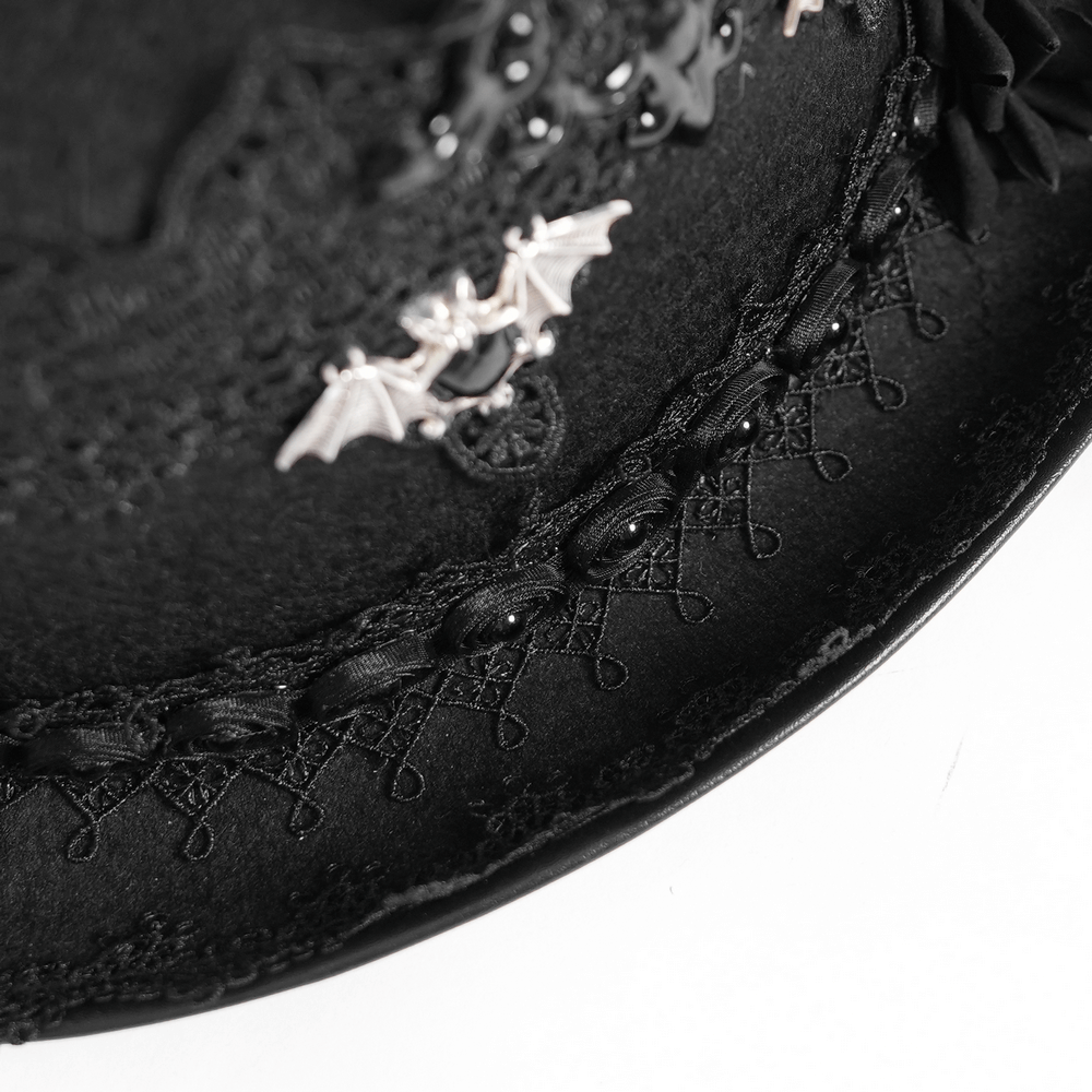 Close-up of a gothic black top hat showcasing bat embellishments and intricate lace details.