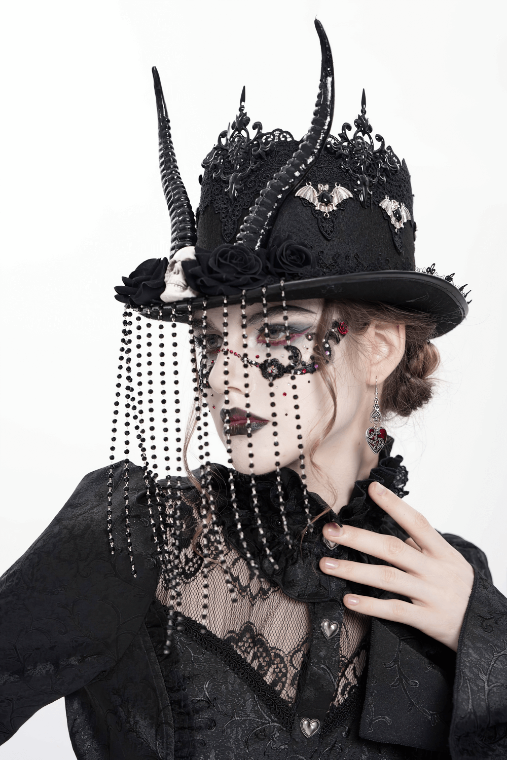 Gothic black horned top hat adorned with skull, lace, roses, and bead chains, perfect for dark fashion.