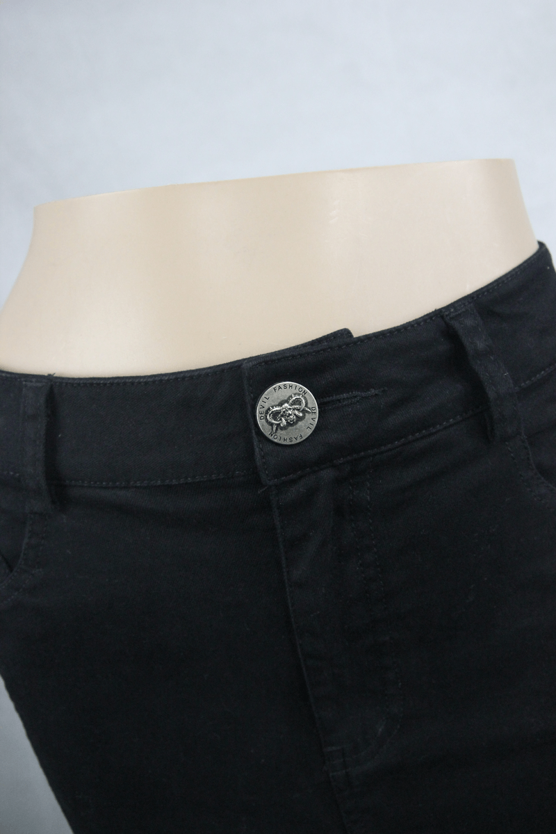 Close-up of a black irregular skirt for women featuring a silver skull button accent, perfect for gothic fashion.