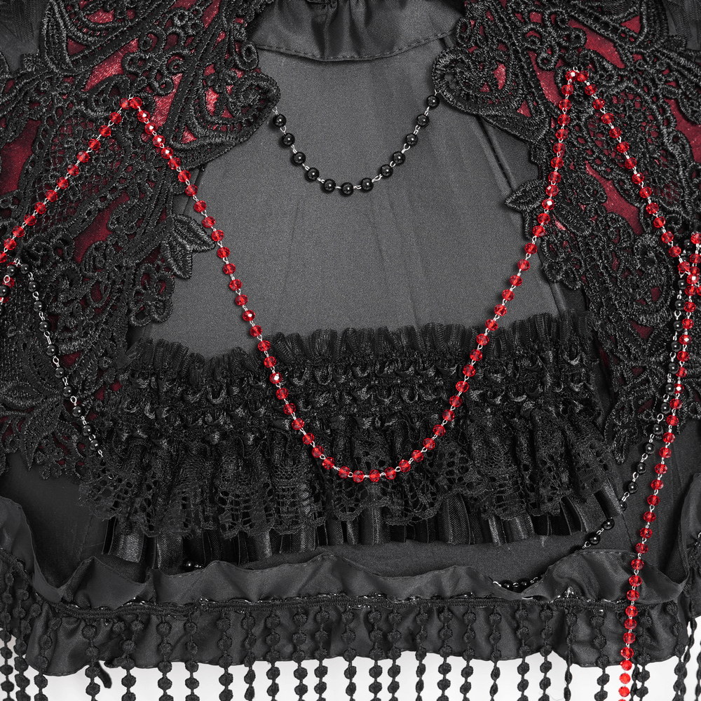 Close-up of gothic black lace with red bead fringe, showcasing intricate detailing and elegant design.
