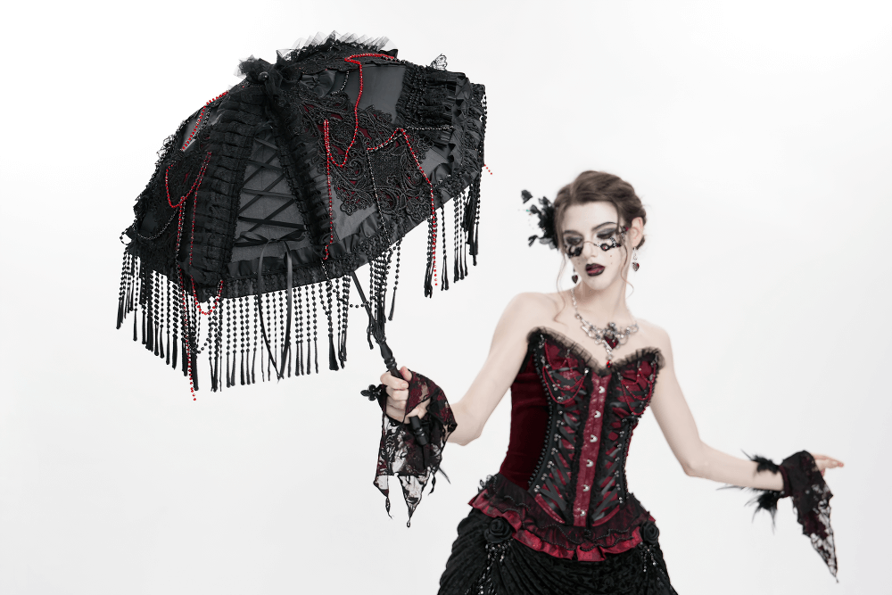 Gothic black lace umbrella with red bead accents, held by a model in a vintage corset.