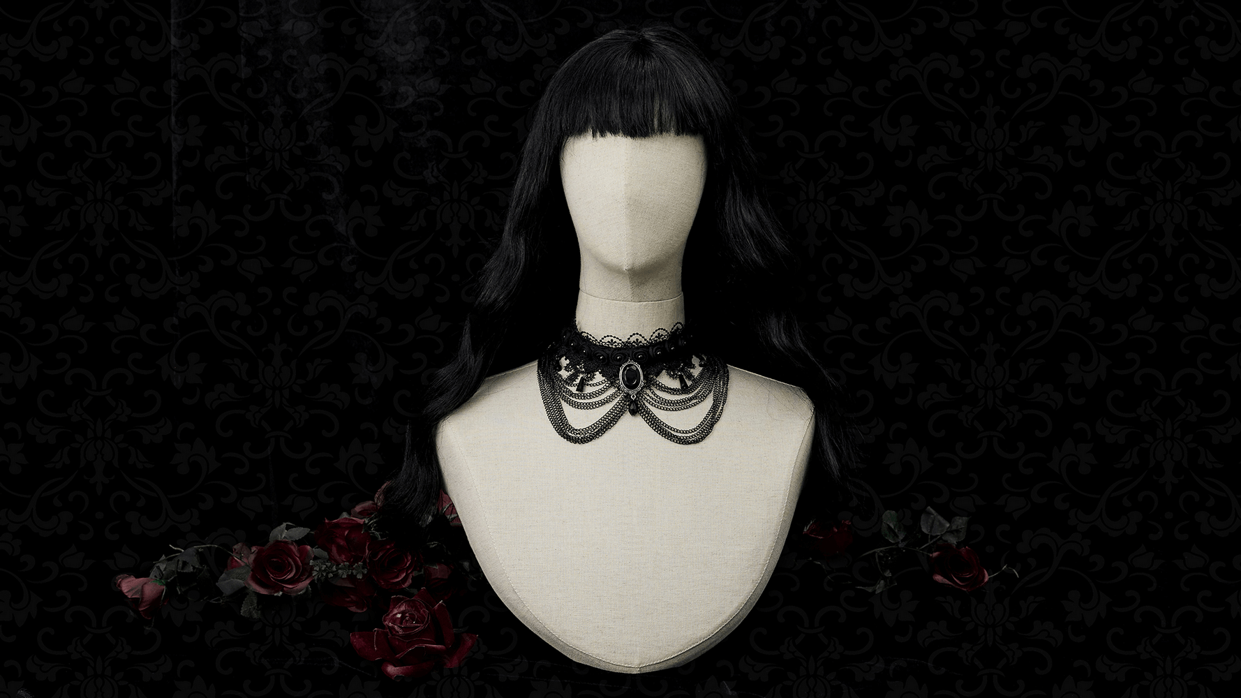 Gothic black lace and chain collar choker with gemstone pendant displayed on a mannequin against a dark floral background.