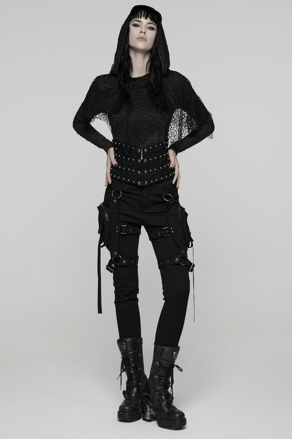 Model showcasing Gothic Black Lace and Rivet Waist Cincher Corset with edgy black attire and stylish boots.