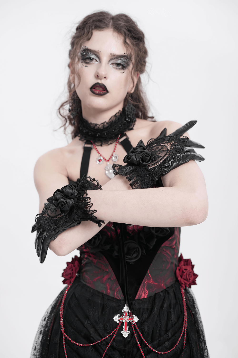Gothic black lace and satin rose gloves with ruffles worn by a model in a dark elegant outfit.