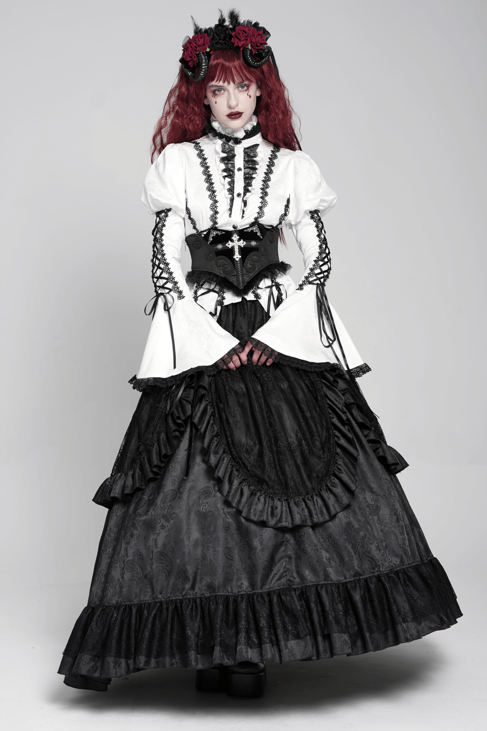 Gothic model wearing a black lace corset belt with cross embroidery, paired with an elegant Victorian outfit and lace accents.
