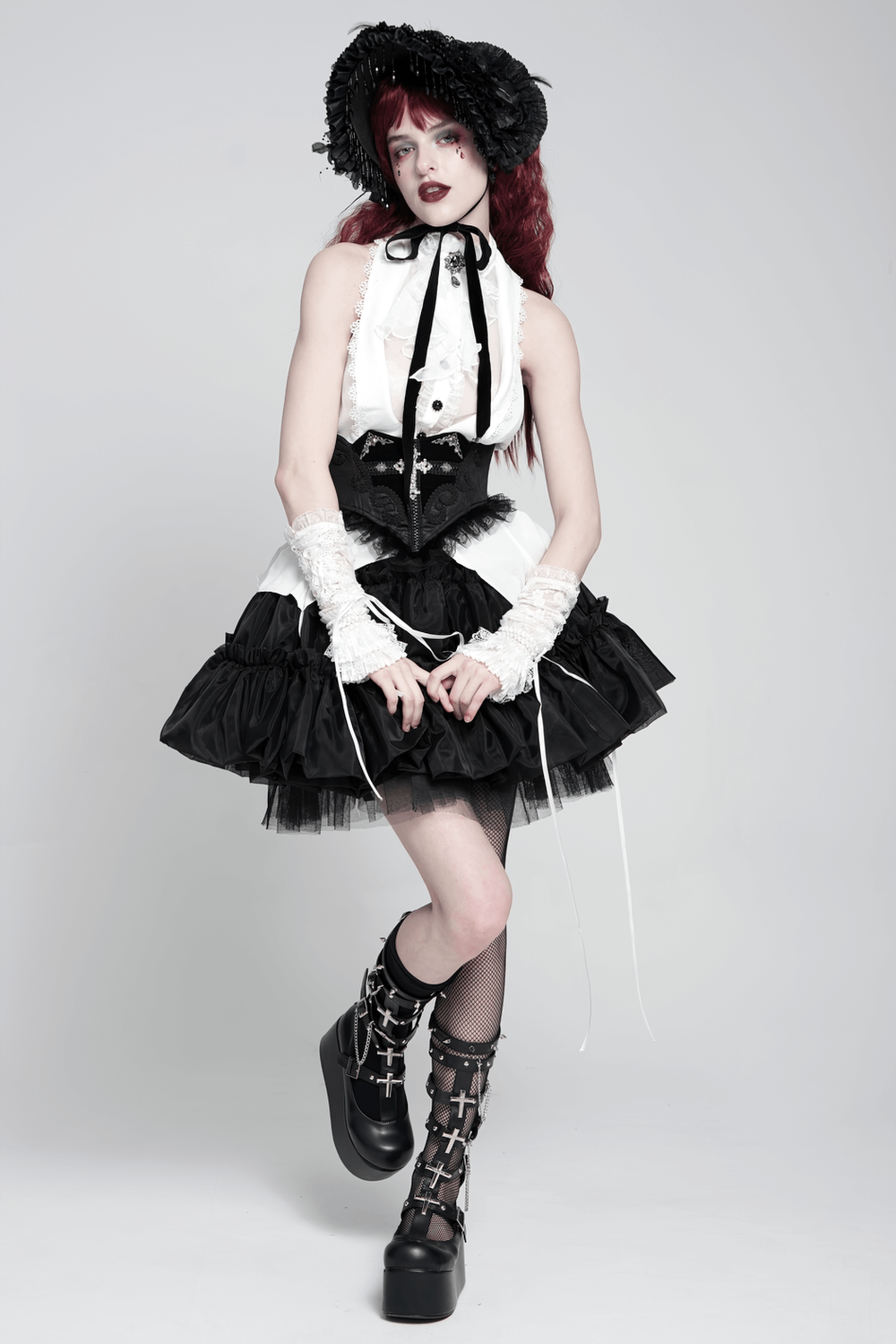 Gothic model in black and white Victorian outfit with corset, layered skirt, and gothic accessories.