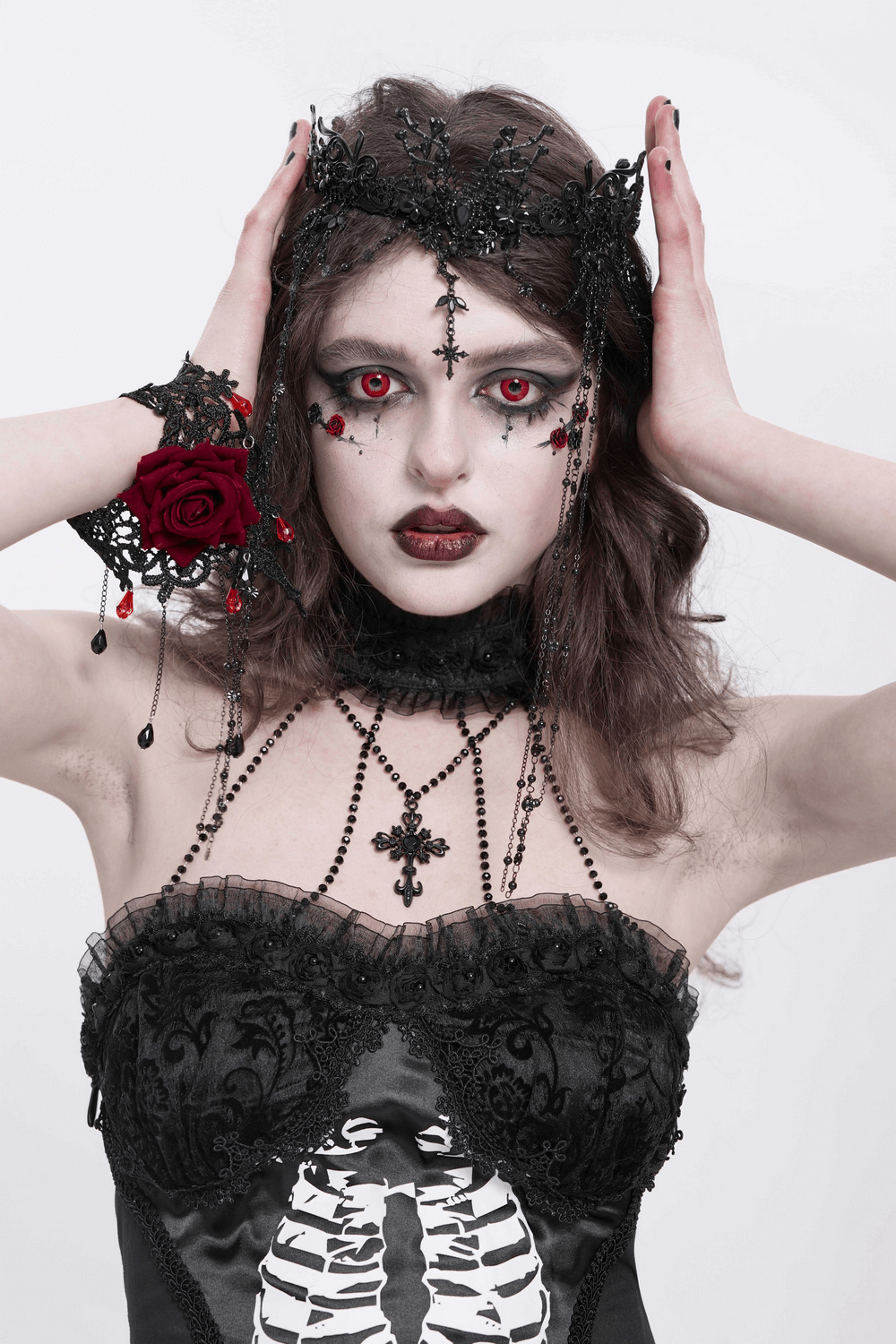 Gothic black lace crown with beaded chains and cross details worn by model with dramatic makeup and styled hair.