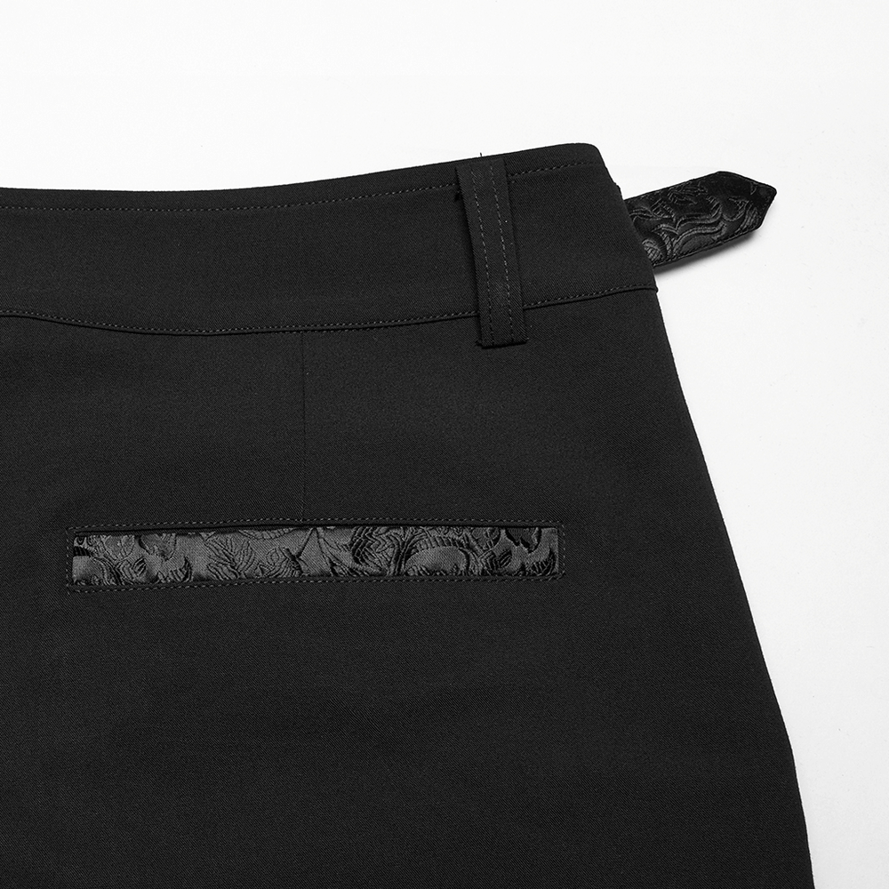 Close-up of gothic black trousers showcasing jacquard detail and adjustable waist with flap pocket.