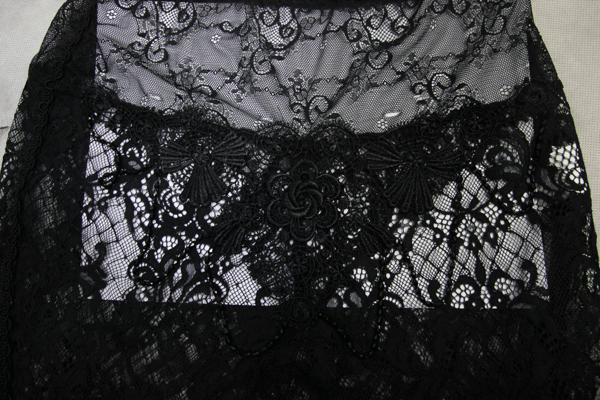 Close-up of elegant black lace fabric showcasing intricate patterns for gothic style pants.