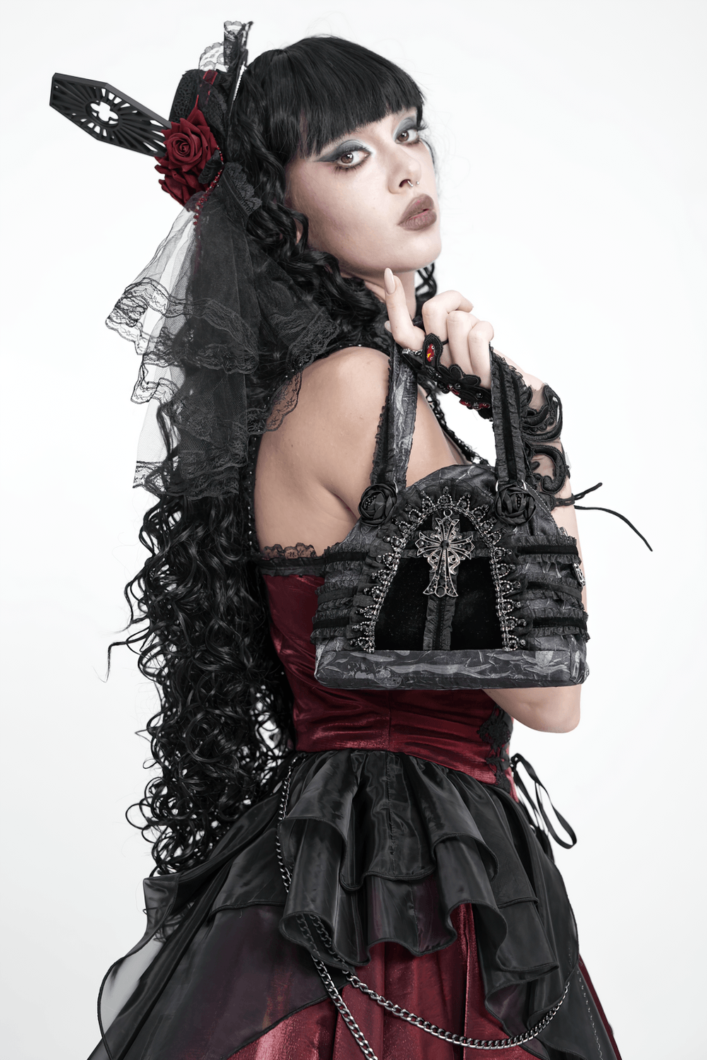 Gothic Black Lace Handbag with Cross and Rose Details held by a model in a dark romantic outfit.