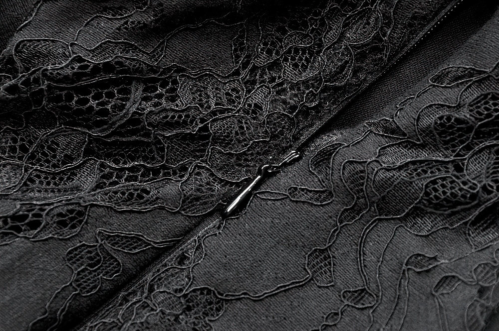 Close-up of intricate black lace detailing on a gothic dress, showcasing floral patterns and a zipper.