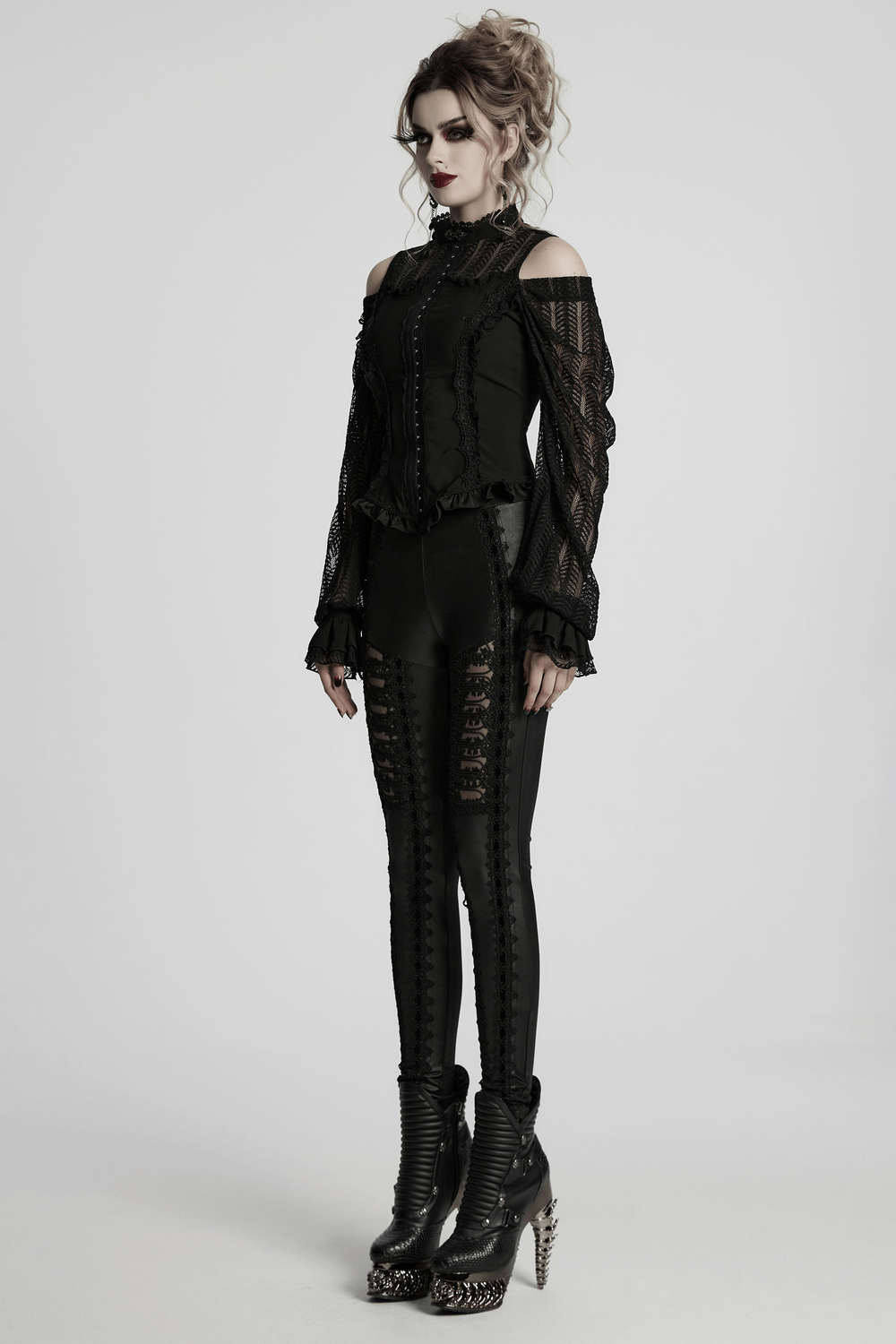 Gothic black lace swing sleeved shirt with ruffles and rose details, styled with edgy leggings and high-heeled boots.