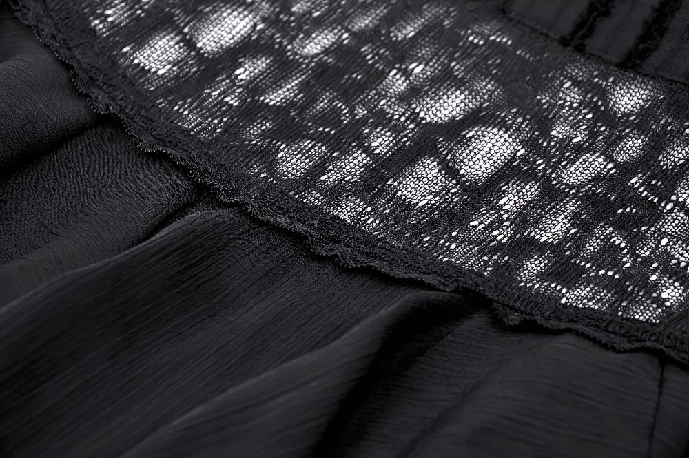 Close-up of gothic black lace trim showing intricate detailing on a blouse's ruffled sleeves and collar.