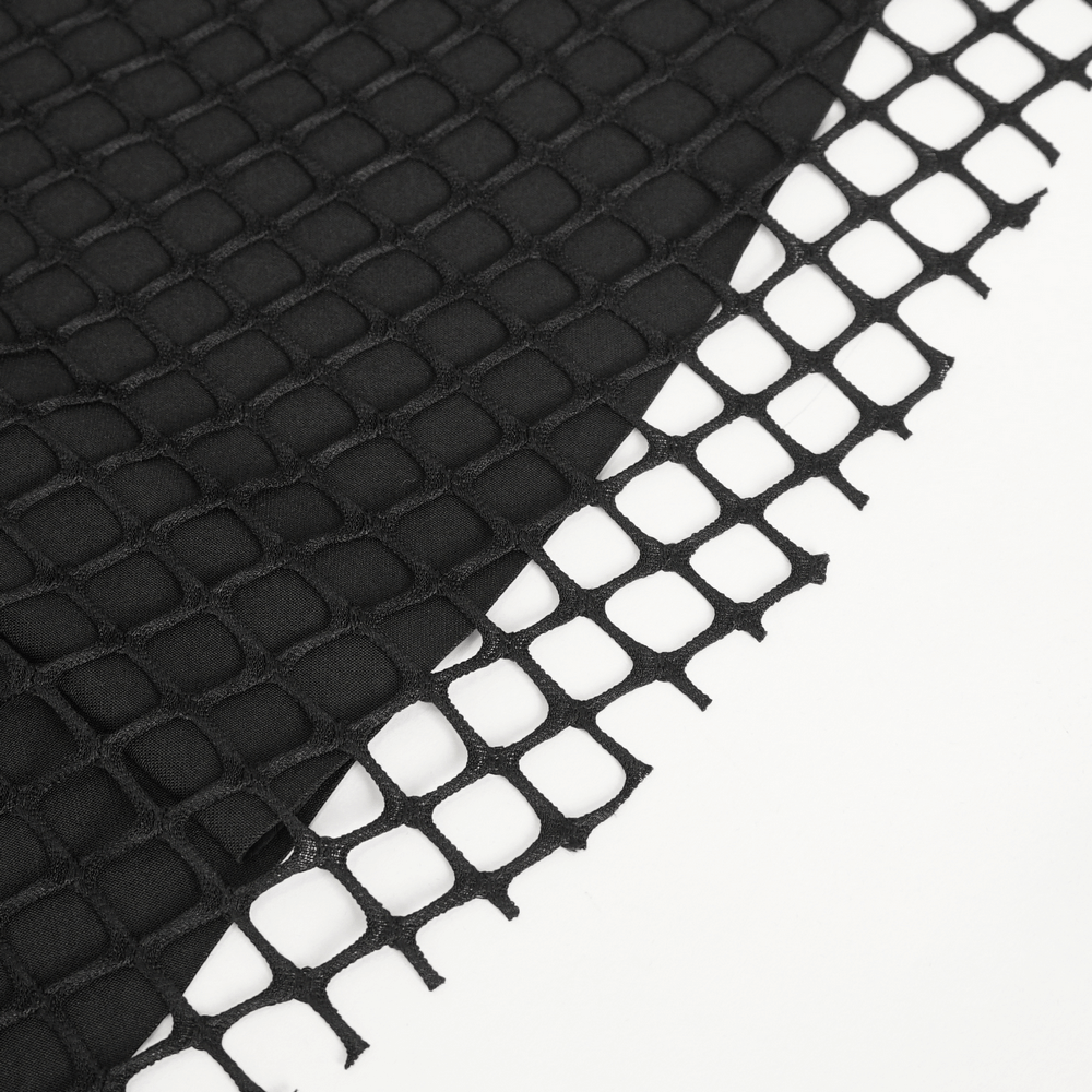 Close-up of black fishnet fabric with a textured background, perfect for gothic dresses and alternative fashion.