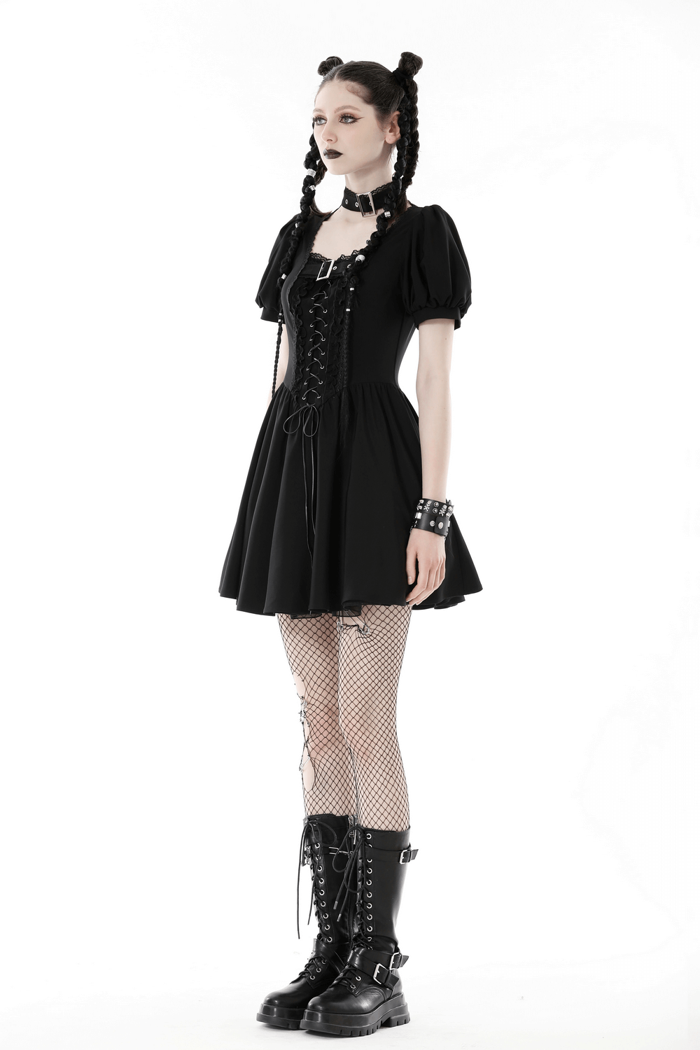 Gothic black lace-up mini dress with puff sleeves, choker, and fishnet tights, showcasing dark aesthetic fashion.
