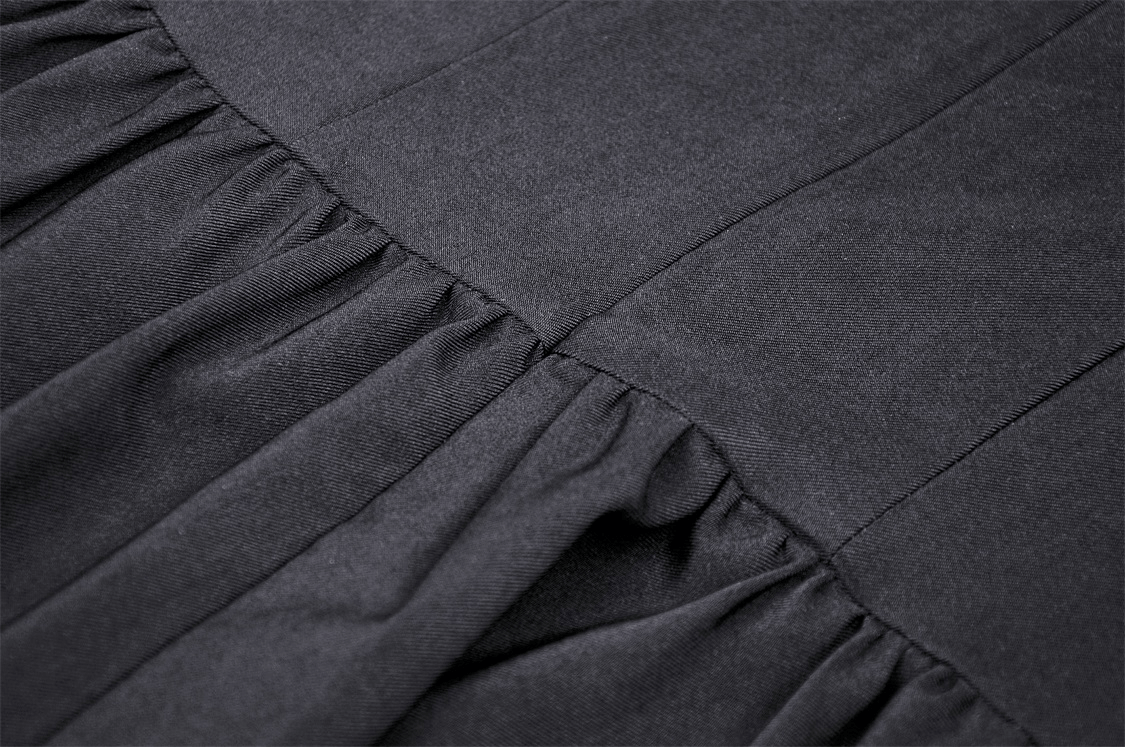 Close-up of ruffled fabric texture from gothic black lace-up dress, showcasing elegant dark aesthetic.