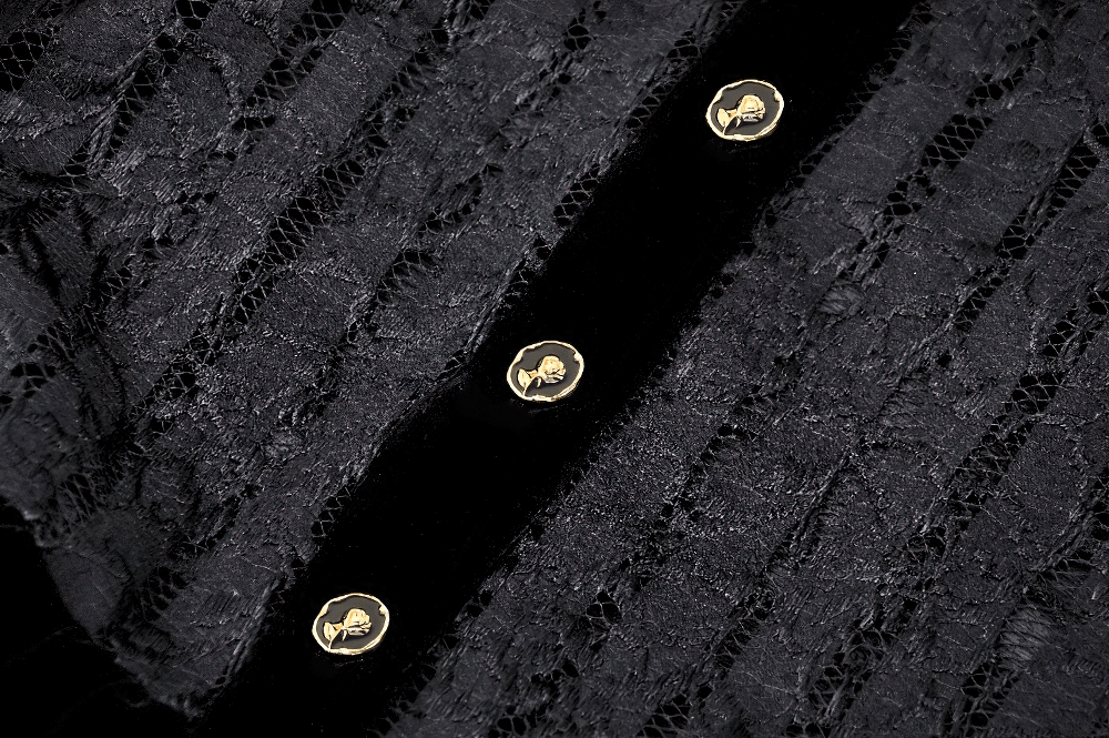 Close-up of black lace and velvet fabric with gold button details on a gothic dress.