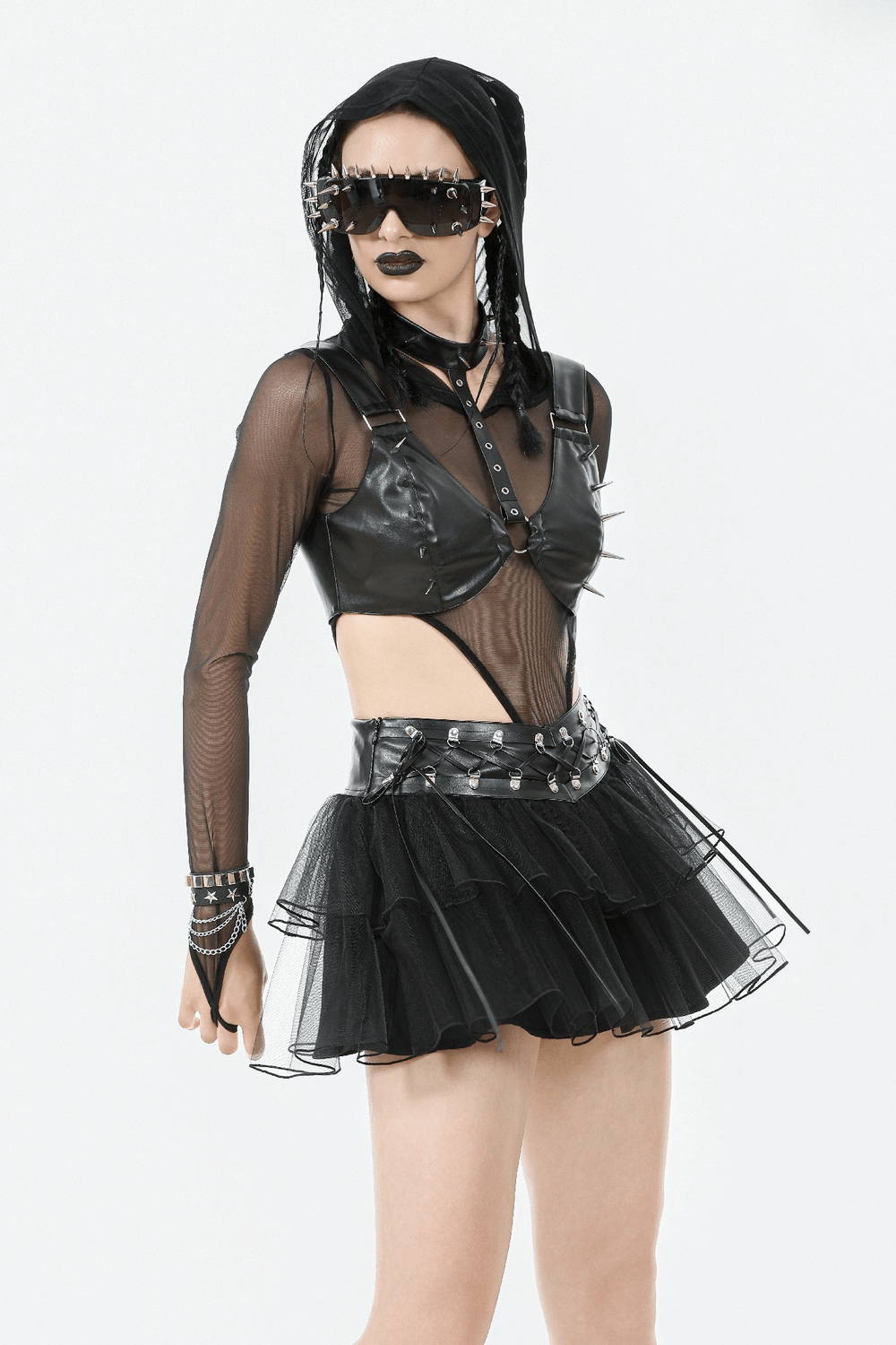 Gothic black layered tulle mini skirt with harness detail, paired with edgy punk attire and bold accessories.
