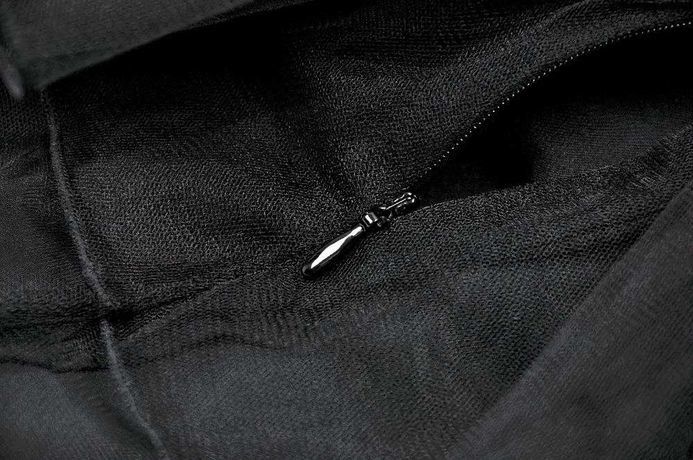 Close-up of a black zipper on a sheer tulle fabric, showcasing gothic mini skirt details and edgy style.