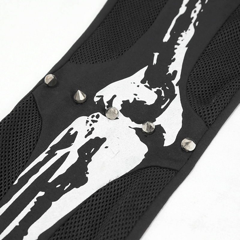 Close-up of gothic black leggings featuring a white skeleton print and metal studs for a stylish look.